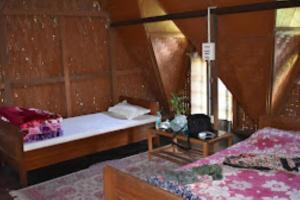Namdapha Jungle Camp Miao的小房间设有两张床和一张桌子