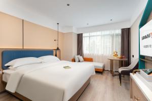 广州宜霖城际酒店(广州白云站国际单位店)的一间酒店客房,设有两张床和电视