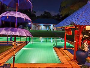 乌布Villa Biyu Siyu的一座房子旁带两把遮阳伞的游泳池
