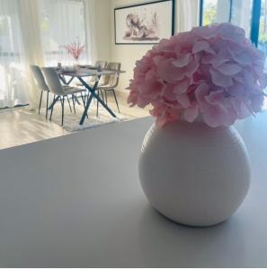 马翁Luna Holiday Home的客厅里白色花瓶,有粉红色的花朵