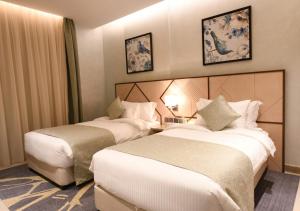 吉达Renee Suites的一间酒店客房,房间内设有两张床