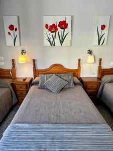 福恩吉罗拉雷耶索尔酒店的一间卧室配有两张床,墙上有两幅画作