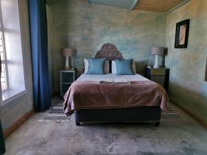 博福特西Silwerkaroo Gastehuis的一间卧室配有一张带蓝色枕头的大床
