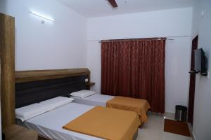 班加罗尔B Six Hotel的一间设有两张床和红色窗帘的房间
