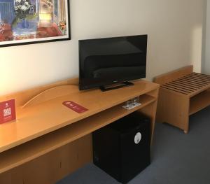 圣地亚哥－德孔波斯特拉中心区EXE酒店的一间配备有书桌的客房,配备有一台电视。