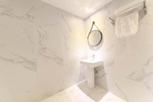 釜山HOUND HOTEL sasang branch的白色的浴室设有水槽和镜子