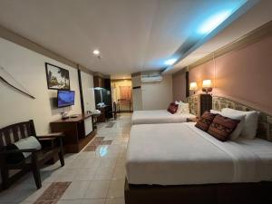Ban Nong Nam Khan帕雅迈度假酒店的酒店客房设有两张床和电视。