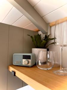 特鲁罗Private and peaceful stay in a Luxury Shepherds Hut near Truro的木架上的收音机和葡萄酒玻璃
