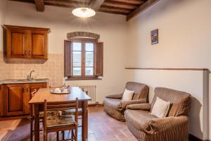 兰波雷基奥Agriturismo Fadanelli La Colombaia的厨房以及带桌椅的起居室。