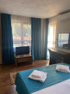 Pasarel卡梅罗酒店的酒店客房配有一张床、一张书桌和一台电视。