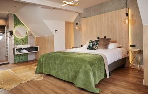 阿尔森De Maasparel Nextdoor Suites的一间卧室配有一张带绿毯的大床
