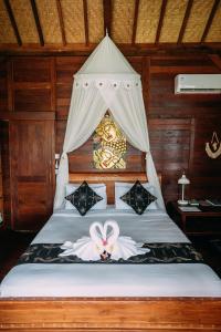 曼格斯WOODEN HOUSE CANDIDASA的一间卧室配有一张带天蓬的床