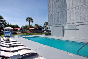 默特尔比奇Willow Bay Resort的一座带躺椅的游泳池位于大楼旁