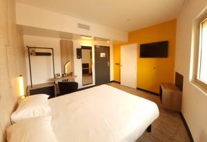 尼斯B&B HOTEL Nice Stade Riviera的卧室配有白色的床和电视。