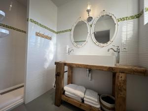 鲁埃格自由城Babolène Shabby Suite的浴室设有水槽和墙上的两面镜子