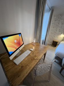 鲁埃格自由城Babolène Shabby Suite的一张木桌,上面有一台电脑
