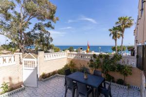 格兰阿利坎特rentafive Nuevo Barbacoa Terraza Playa的俯瞰大海的庭院内的桌椅