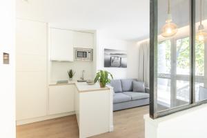 蒙彼利埃Les appartements de Montpellier的白色的厨房和带沙发的客厅