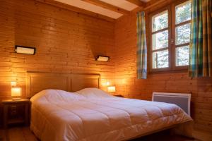 圣但尼Les Bouviers的卧室配有木墙内的一张床