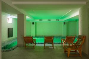 伊万诺-弗兰科夫斯克GANZ HOTEL的绿色客房 - 带椅子和游泳池