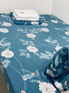 香港KATHMANDU GUEST HOUSE的一张带白色花朵的蓝色毯子,放在桌子上