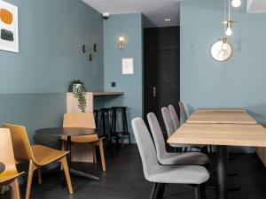 瓦朗西纳宝度酒店的用餐室配有木桌和椅子