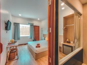 格兰岛Thandara kohlarn的一间卧室设有一张床、一个窗口和一台电视