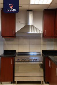 迪拜Rovers Hostel Dubai的厨房配有不锈钢炉灶 顶部烤箱