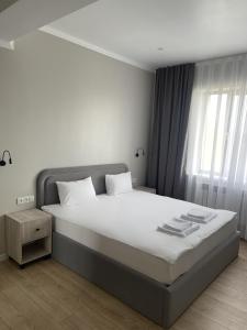 奇姆肯特BnB Hotel Shymkent的一间卧室设有一张大床和一个窗户。