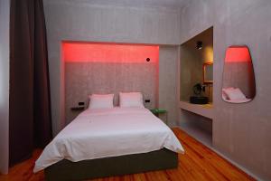 塞萨洛尼基Paradox的一间卧室配有一张白色的红灯床