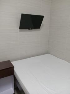 香港富都賓館 Fu Dou Guest House的一间设有床铺和墙上电视的客房