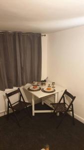 特灵Welcome to Tring Cymric Home的客房内的一张白色桌子和两把椅子