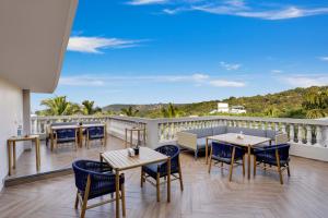 坎多林Antarim Resort的阳台的天井配有桌椅