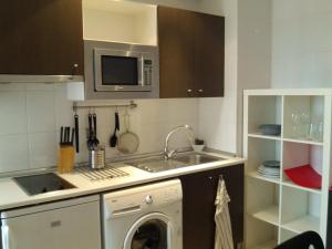 马德里卡勒马里西奥勒让德公寓的厨房配有洗衣机和微波炉。