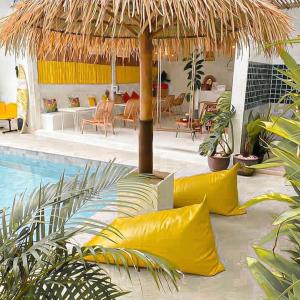 格兰岛Thandara kohlarn的一个带黄色枕头和草伞的游泳池