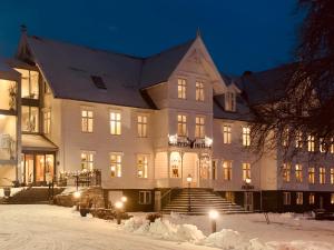 桑纳讷Gloppen Hotell - by Classic Norway Hotels的雪中的一个白色大建筑