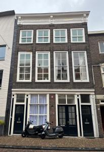 多德雷赫特Artistic apartment, City Centre Dordrecht的停在砖楼前的摩托车