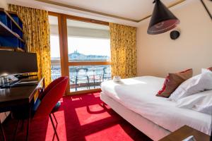 马赛老港口酒店的配有一张床、一张书桌和一扇窗户的酒店客房