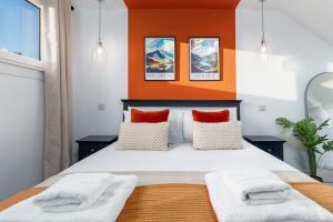 斯特灵The Stylish 3-Bedroom Maisonette Retreat的一间卧室配有一张带橙色墙壁的大床