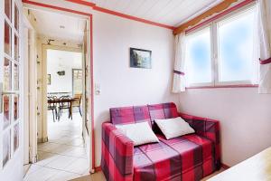 RochessonLe Chalet Sous les Sapins - Superbe vue的客厅里一张红色的沙发,配有桌子