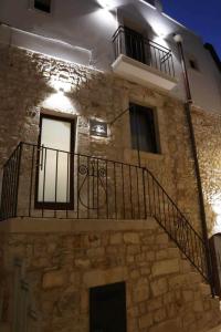图里La Casetta b & b的一座石头建筑,设有楼梯和阳台