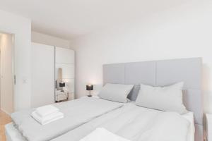 斯图加特Schöne 2 Zimmer Wohnung zentral in Stuttgart West的白色卧室配有白色大床和白色枕头