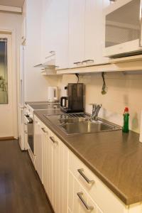 拉赫蒂Lahti Furn House的厨房配有白色橱柜和不锈钢盥洗盆