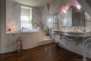 Sainte-Catherine-de-FierboisVilla Alecya的大型浴室设有两个盥洗盆、一个浴缸和镜子
