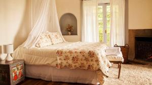 皮尔克Casa Origen的一间卧室配有一张带天蓬的床和一个壁炉