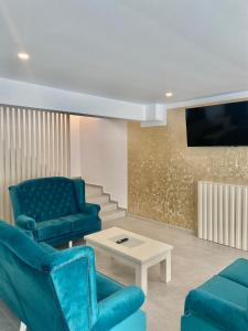 卡夫尼克Royal Alpin Crown的客厅配有蓝色椅子和电视