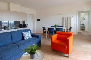罗马Appartamenti Tre Fontane的客厅配有蓝色的沙发和橙色的椅子