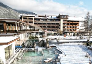 佩尔蒂绍Rieser Achensee Resort的雪地中带游泳池的度假村