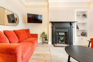 圣安德鲁斯St Andrews - 5 min walk to centre的客厅配有橙色沙发和壁炉