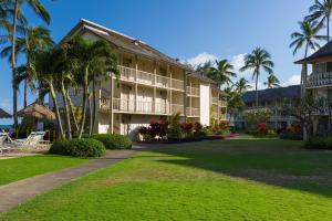 卡帕阿海滩雅诗顿艾兰德酒店的一座拥有棕榈树和草坪的度假建筑